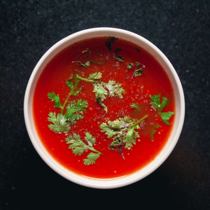 Bowl of homemade tomato soup with garnish.