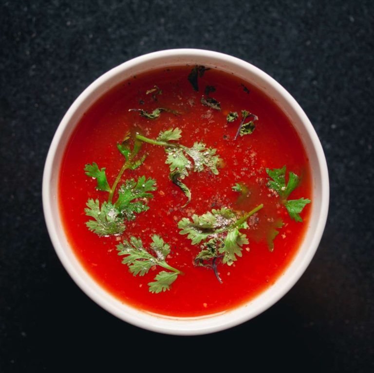 Bowl of homemade tomato soup with garnish.