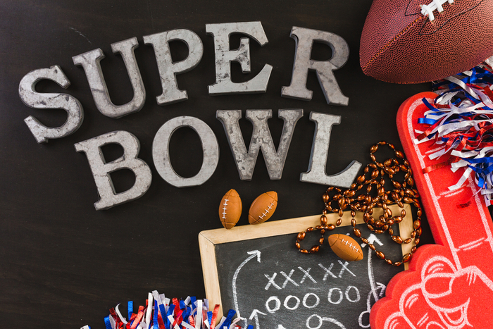 Super Bowl flatlay. A flatlay of football fan paraphernalia and letters spelling out Super Bowl (showing that Super Bowl is two words).