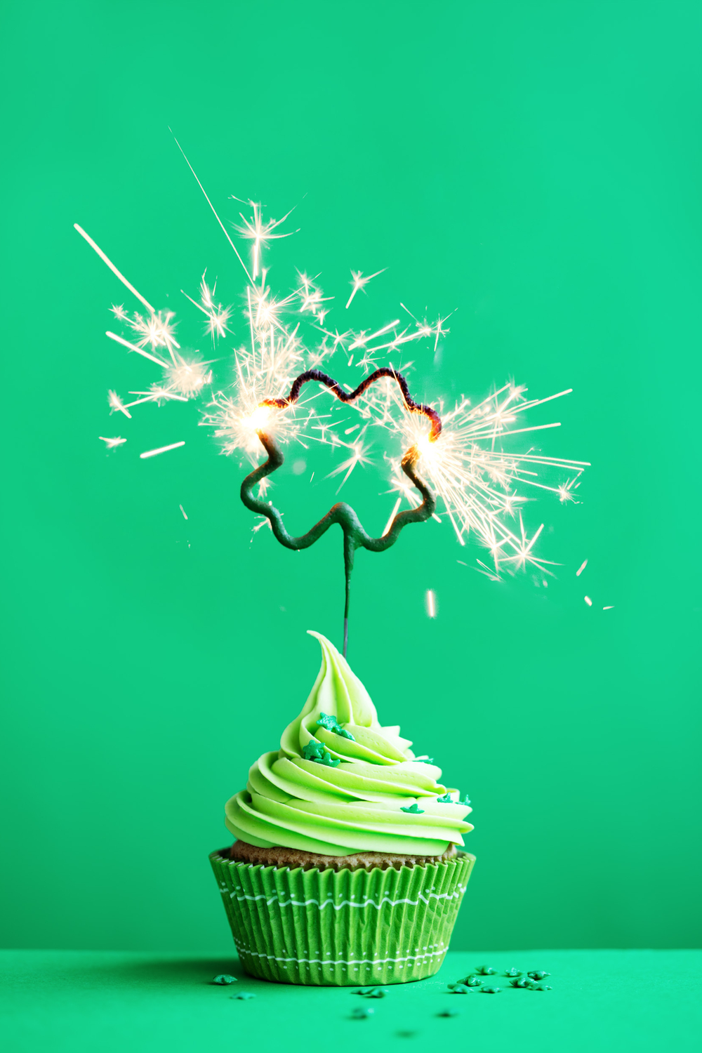 St. Patrick's Day cupcake. A cupcake with green icing and a sparkler in the shape of a shamrock to wish everyone a happy St. Patrick's Day.