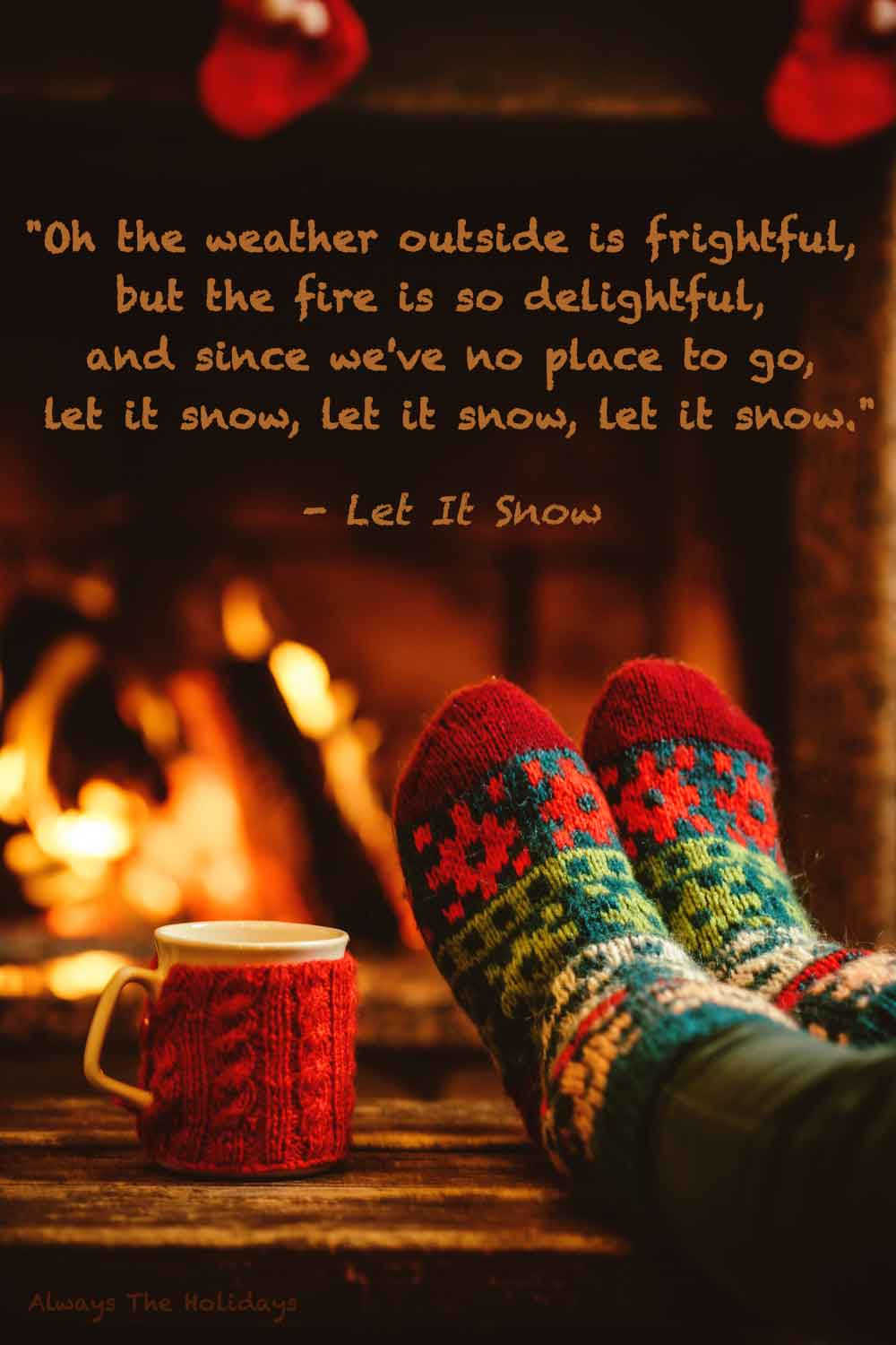 Feet on a coffee table with festive socks next to a mug in front of a crackling fire with a text overlay of quotes from Christmas songs.
