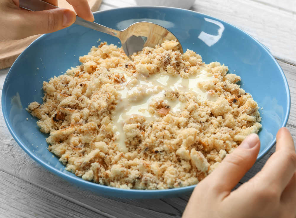 Cake crumbs with vanilla frosting in a blue bowl.