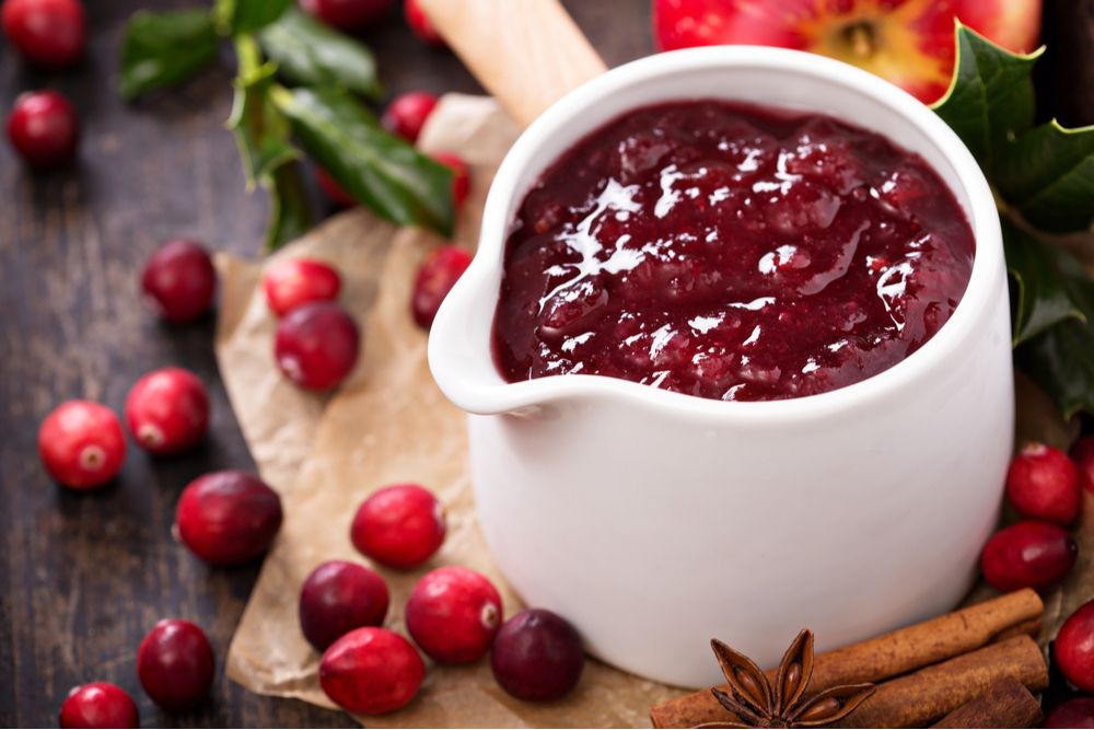 Jar of cranberry sauce. A white porcelain dish of cranberry sauce to illustrate the difference between cranberry relish vs cranberry sauce.