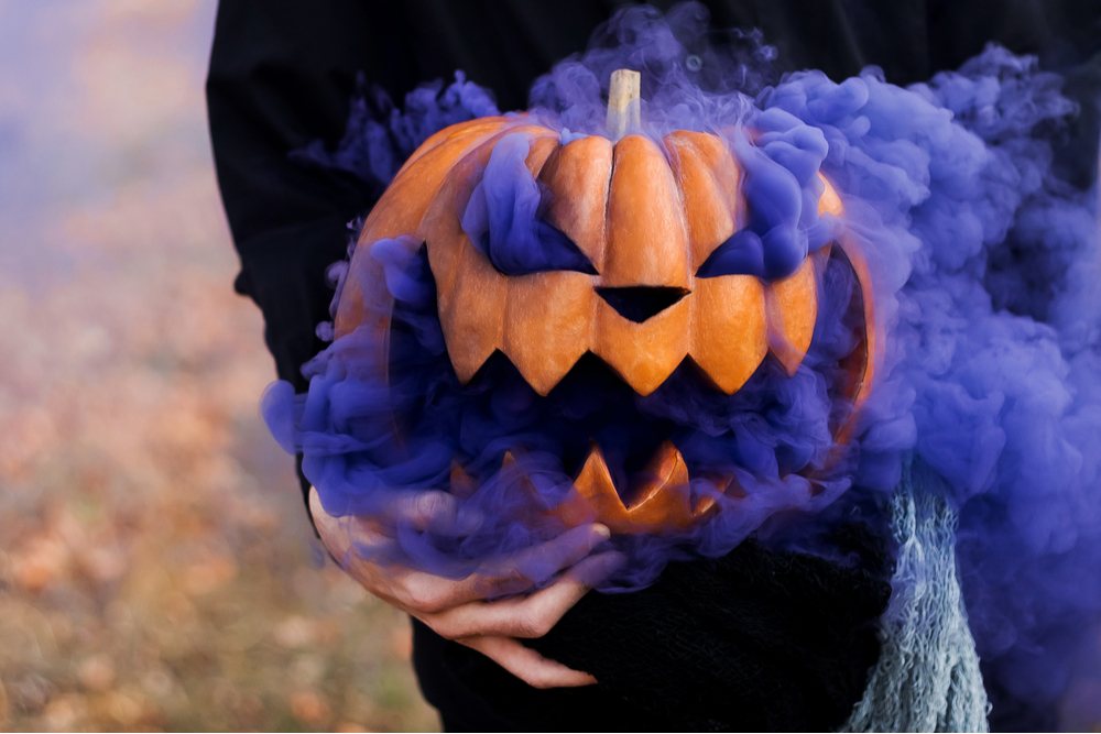 Pumpkin with purple smoke. A jack o lantern carved with a smile that has purple smoke coming out of it, a very creative pumpkin carving ideas.