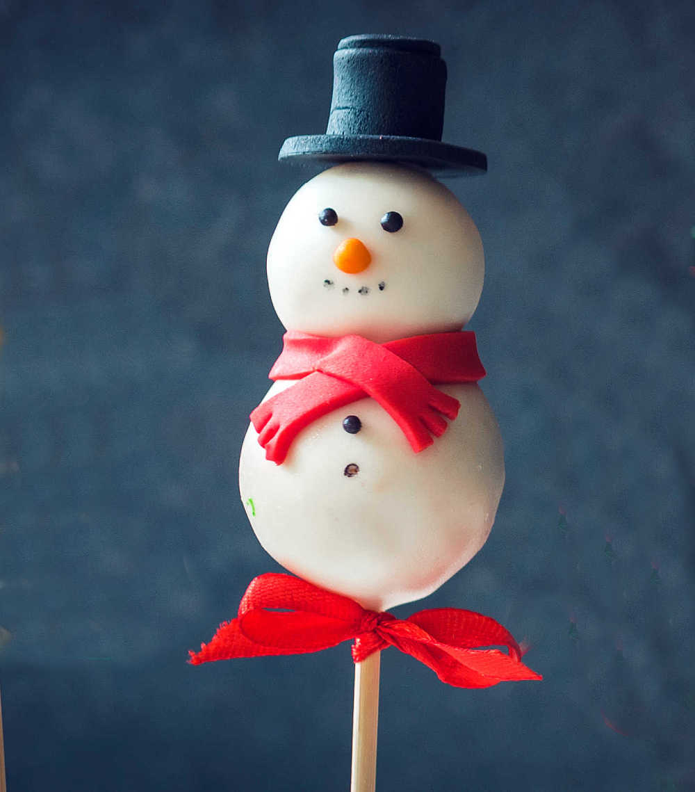 Snowman cake ball with ribbon and top hat.
