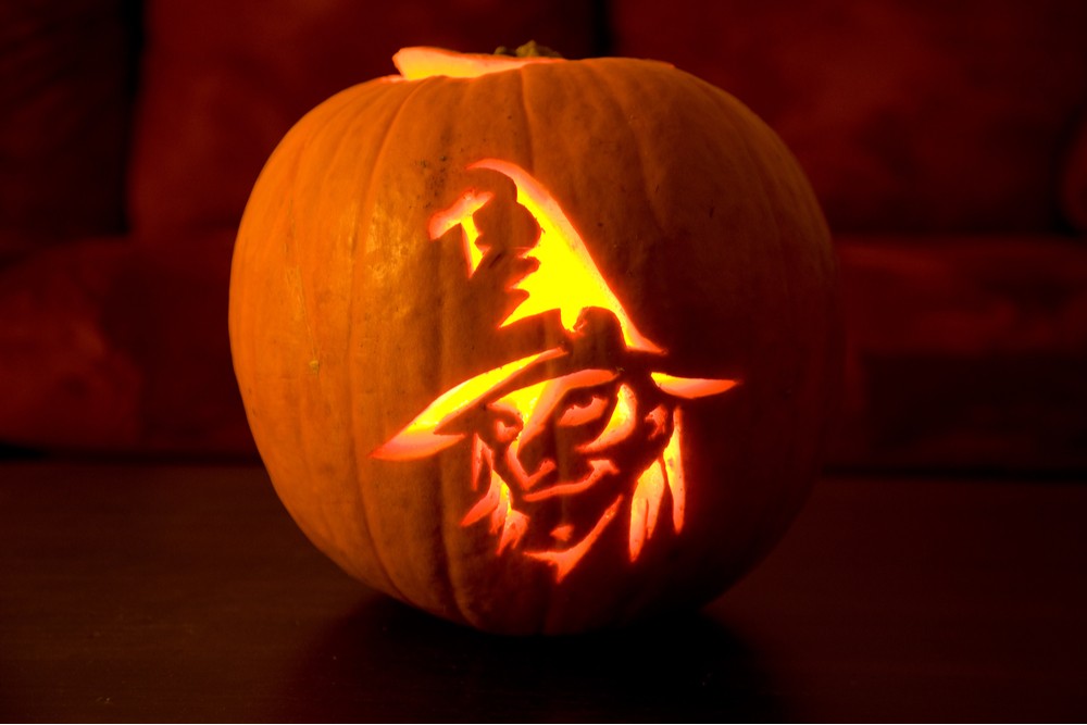 A witch face pumpkin. A witch face pumpkin carving on a table.