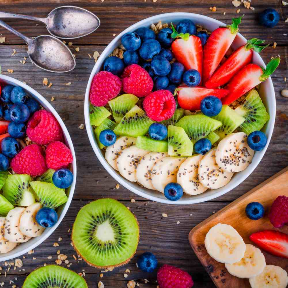 Fruit bowl. A fruit bowl with strawberries, blueberries, raspberries, kiwi and oats with various fruit styled around it.