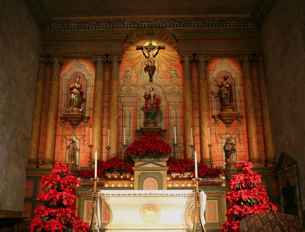 Church and poinsettias. A church with religious imagery and poinsettias as a nod to the religious poinsettia history.