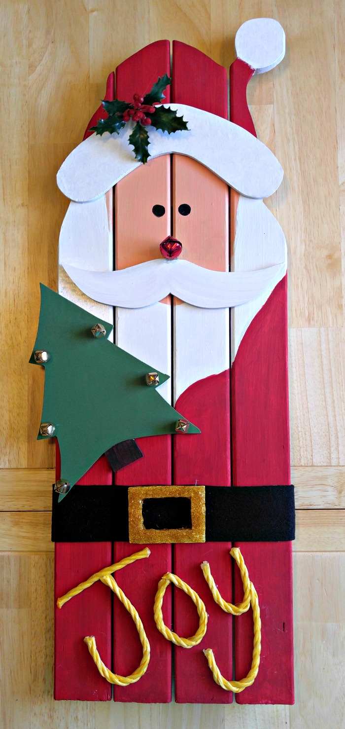 A wooden DIY Santa craft wall hanging, where the entire craft is made of wood, and is painted to look like Santa.