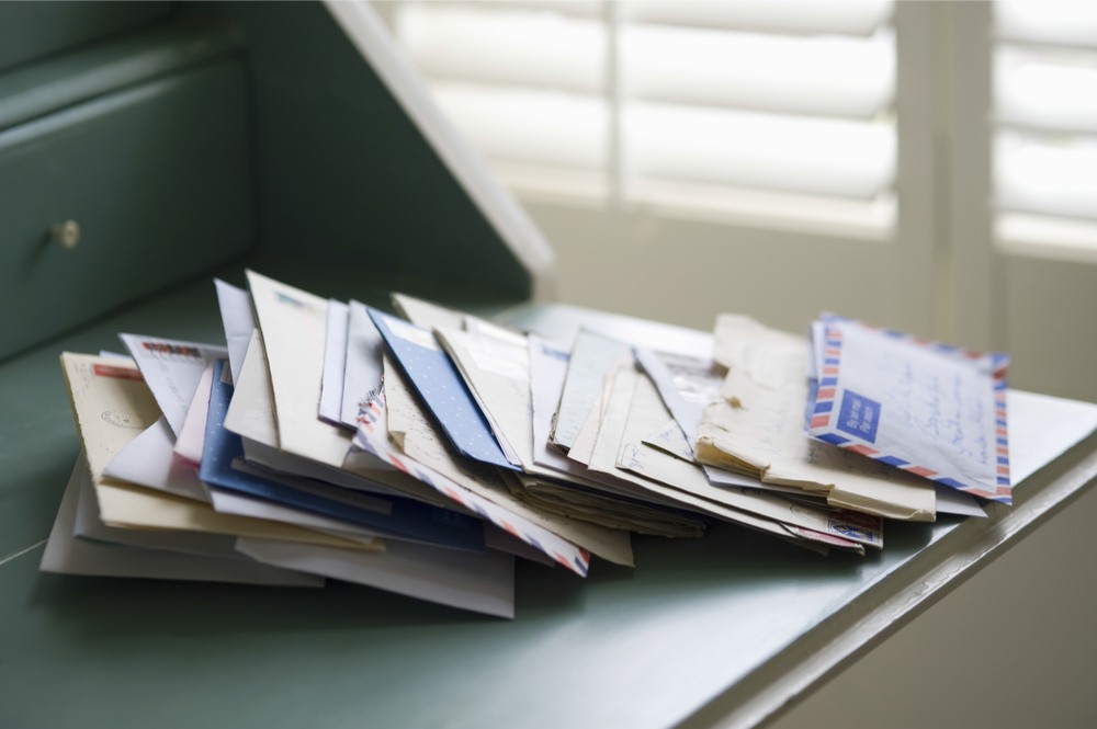 Desk filled with mail A stack of mail and Christmas cards in envelopes on a green desk to honor Louis Prang, the father of American Christmas cards.