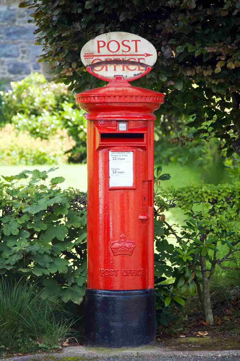 A British postbox against greenery.