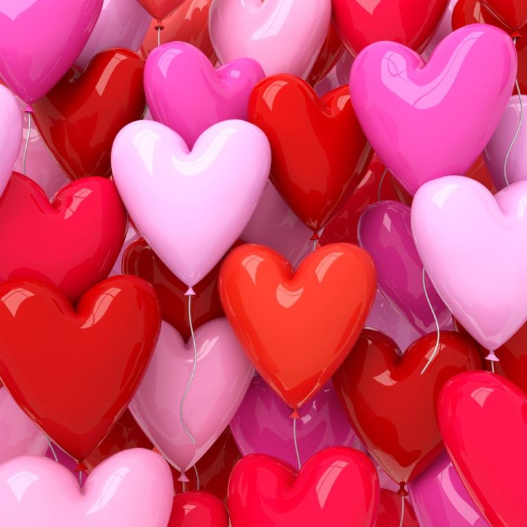 Heart shaped balloons in Valentine's Day colors like pink, red and white filling the entire photo.