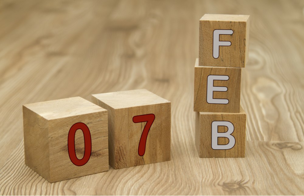 Feb 07 blocks Blocks that say Feb in white lettering and 07 in red lettering on a wooden table top.