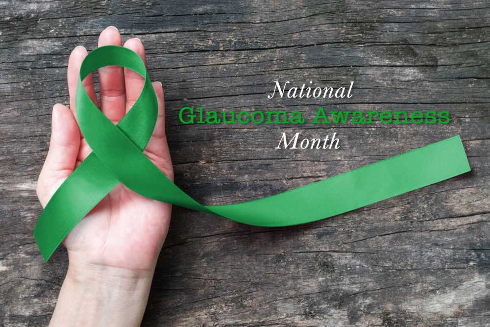 It's glaucoma awareness month! Hand holding a green ribbon with words national glaucoma awareness month.