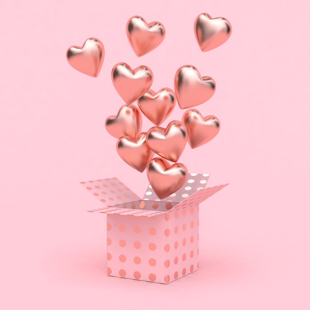 Pink heart balloons escaping a box A pink box with pink heart shaped balloons coming out of it against a pink background.