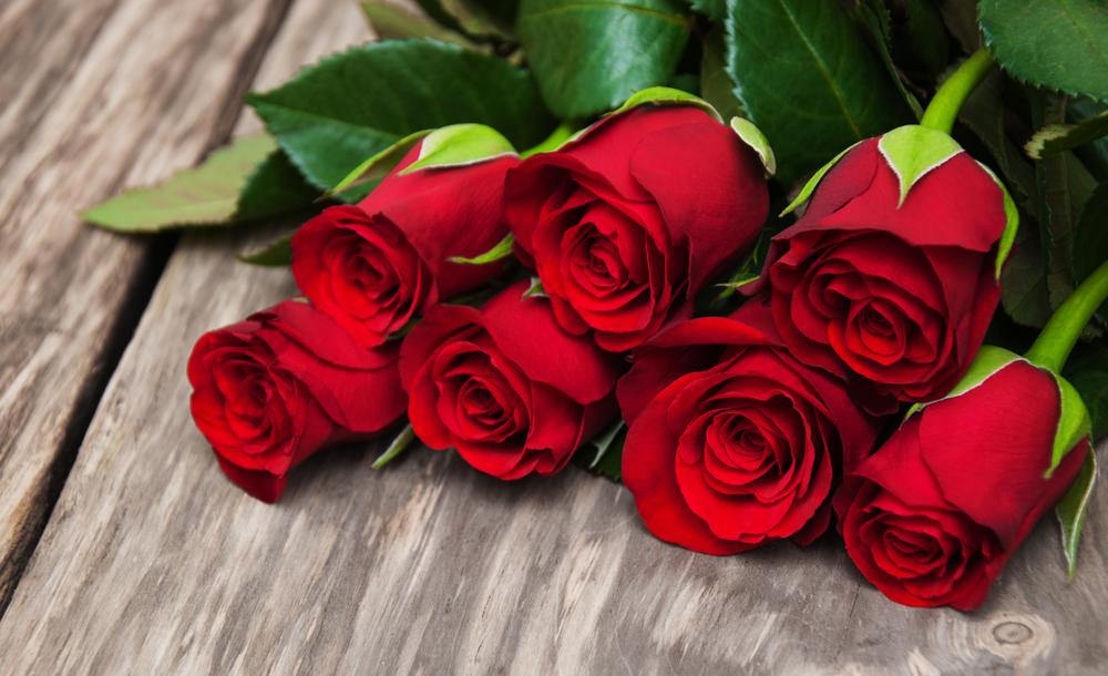 A bouquet of red roses on a wooden background on Valentine's Day.