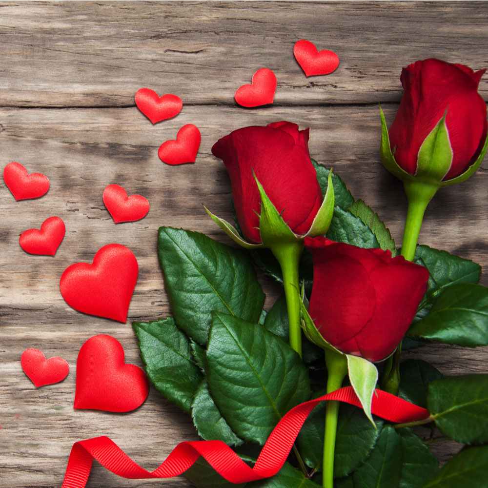 Two Valentine's Day symbols, hearts and roses on a wooden background.