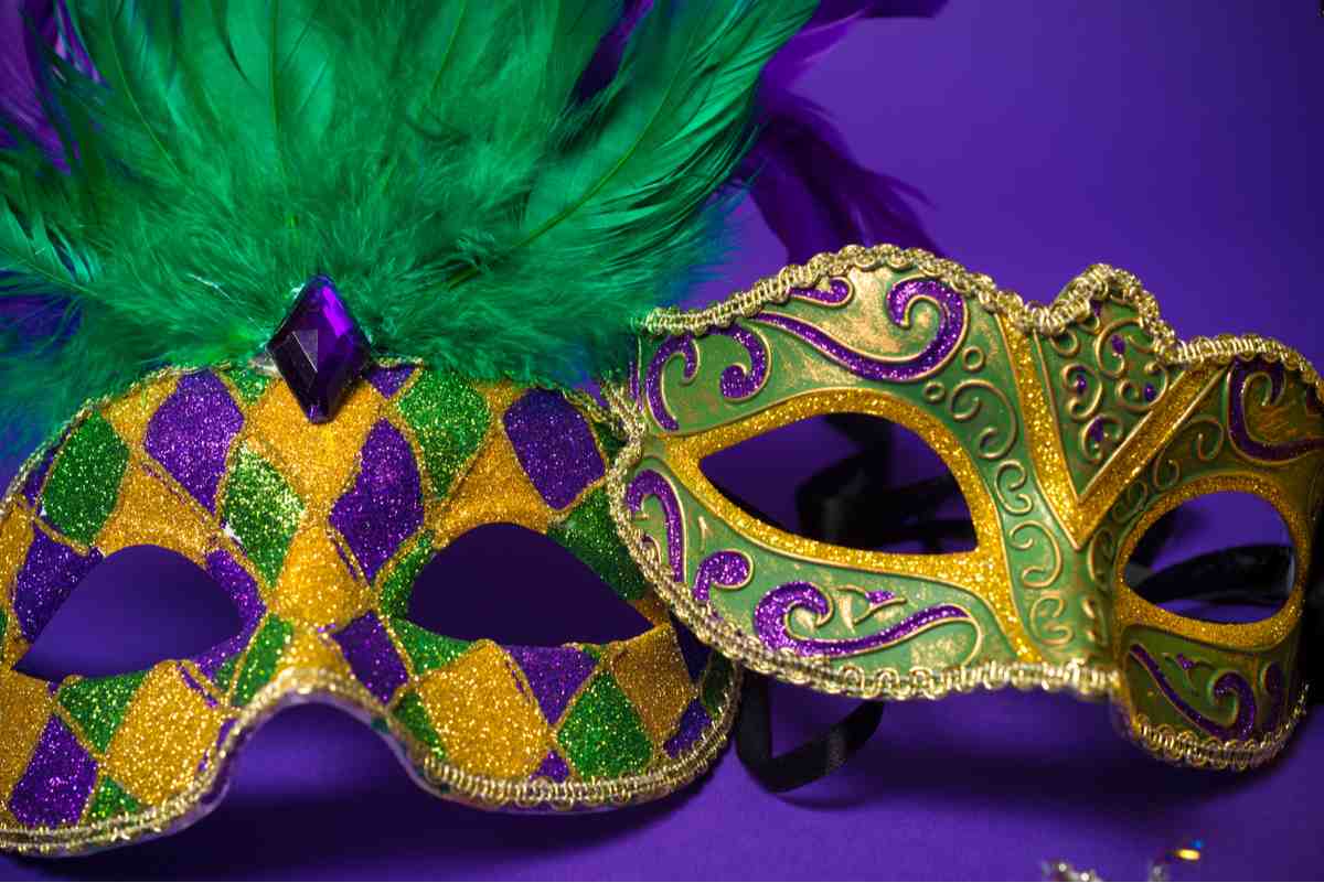 Mardi Gras masks Two Mardi Gras masks in the official colors of Mardi Gras, the one on the left has feather and a diamond patter, while the one on the right has a painted swirl pattern.