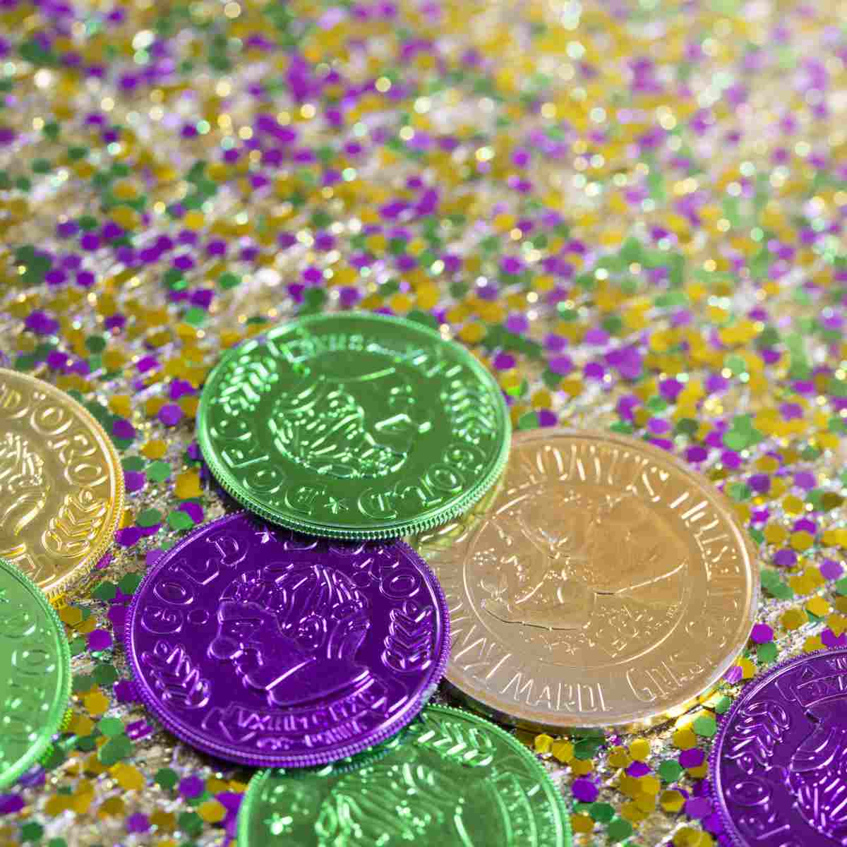 Rex doubloons Green, purple and gold Rex doubloons on top of glitter in the colors of Mardi Gras.