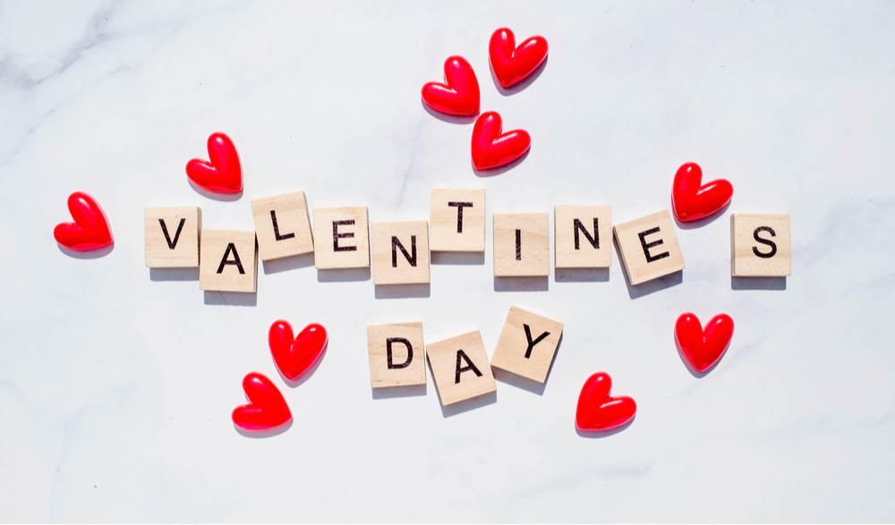 Scrabble "Valentine's Day" tiles Scrabble tiles that read "Valentine's Day" on a marble background surrounded by little red hearts.