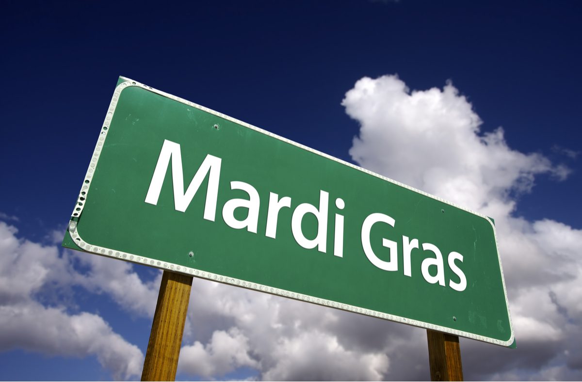 Mardi Gras street sign A street sign that says Mardi Gras against a blue sky with white clouds.