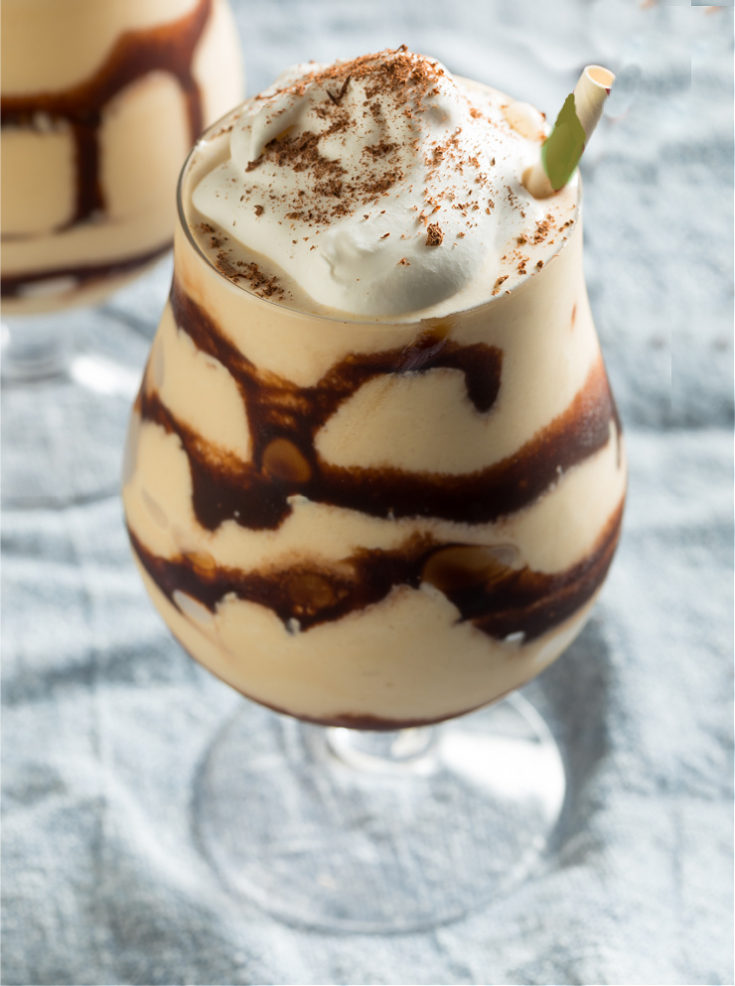 St. Patrick's Day cocktails Two St. Patrick's Day cocktails called mudslides in a stemmed glass with whipped cream on top, and a chocolate drizzle around the glass.