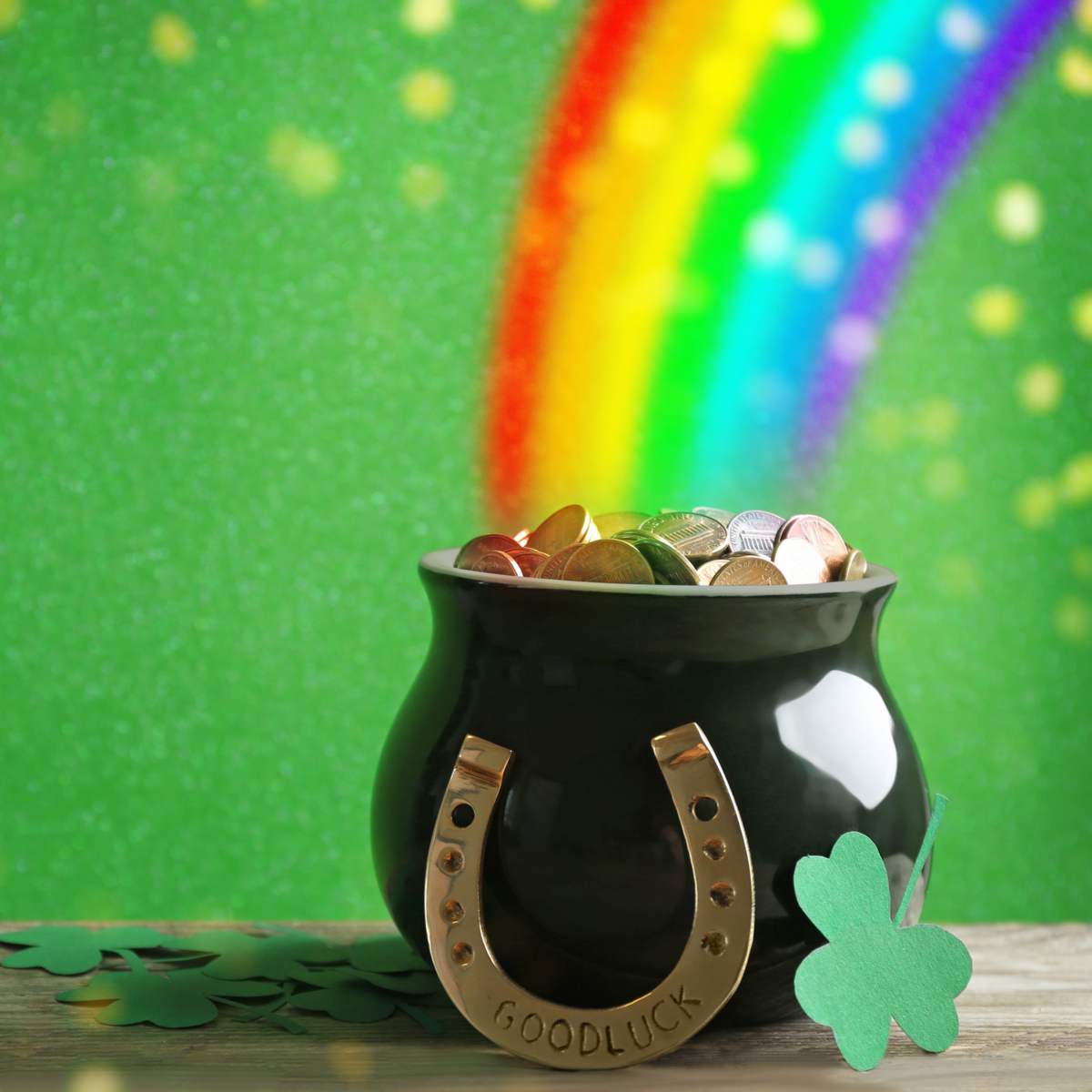St Patrick's Day rainbow and pot of gold A St. Patrick's Day rainbow leading to a pot of gold, with a shamrock and horseshoe reading "good luck' in the front of the photo. It's a great image for National Find a Rainbow Day.