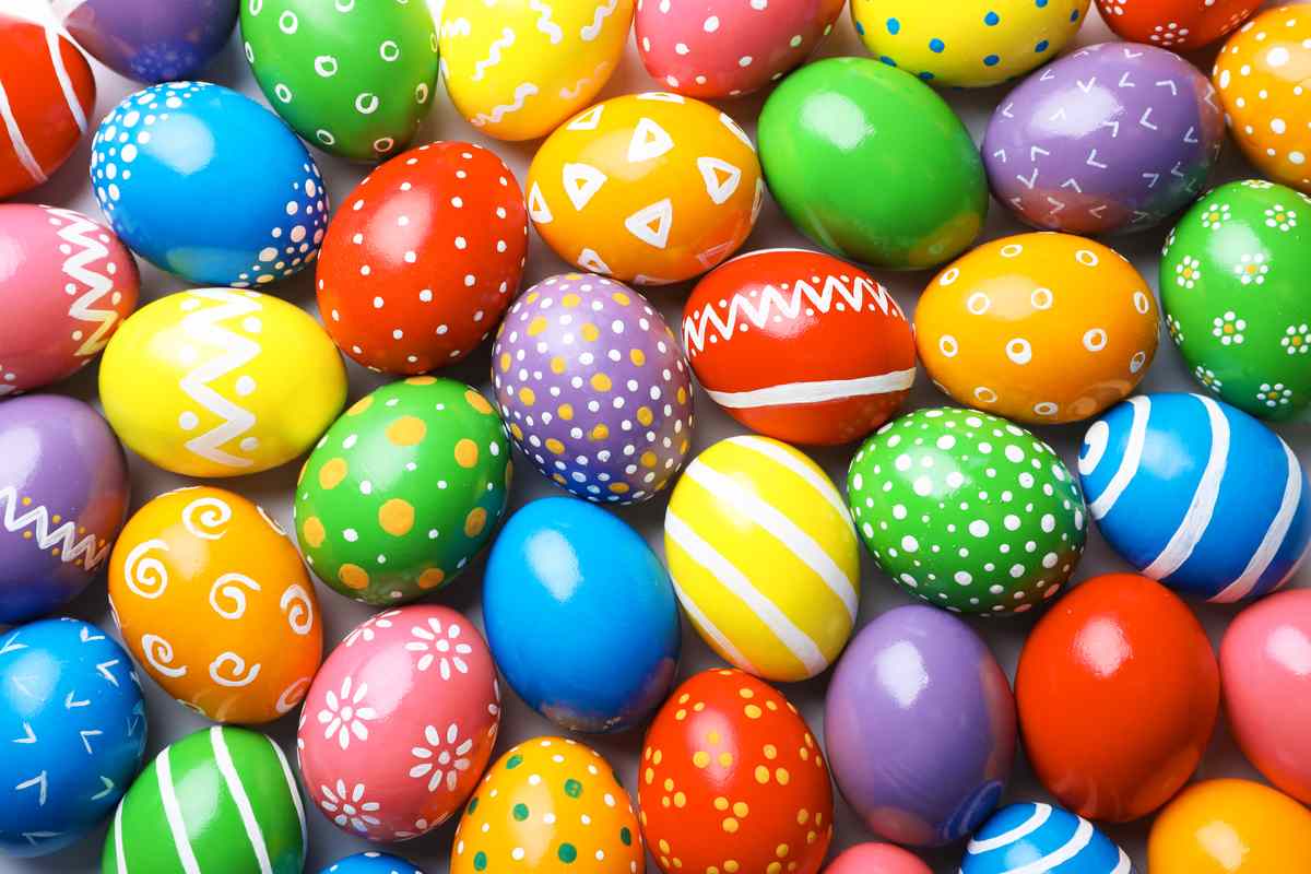 Brightly colored Easter eggs The image completely covered with brightly colored Easter eggs decorated with white designs.