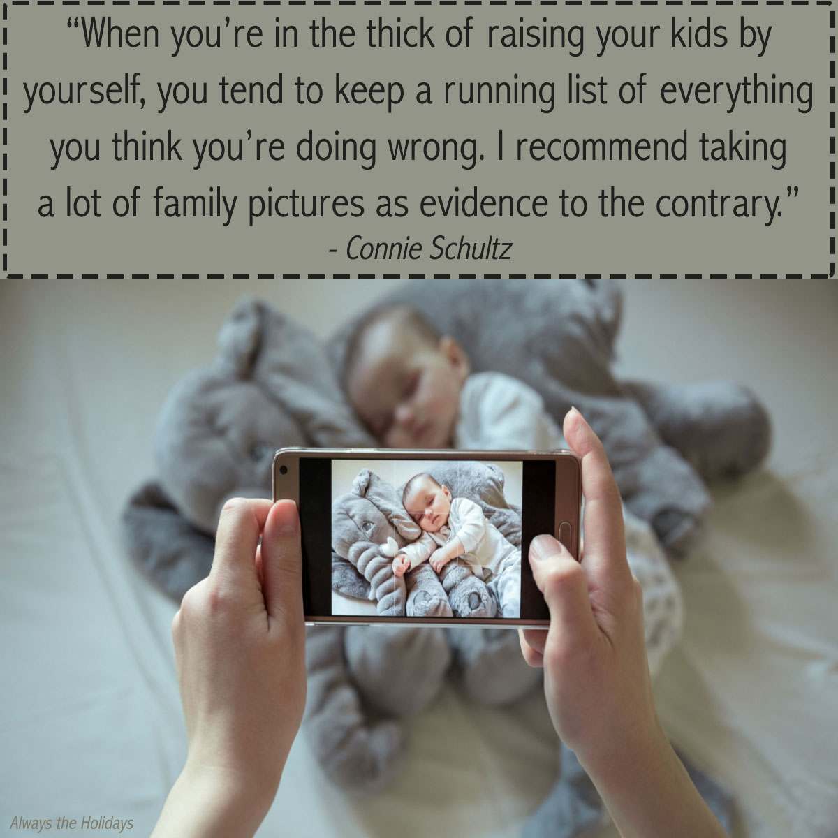 Baby with stuffed animal and mom quote over it A mother quote inspirational text overlay above a cell phone open to a camera in a mothers hands photographing her baby laying on a grey stuffed elephant.