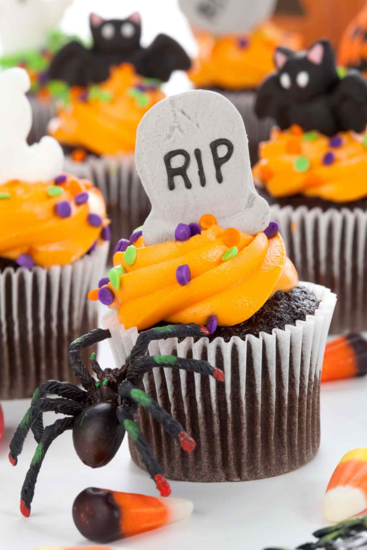 Halloween cupcakes Chocolate halloween cupcakes with orange frosting and sprinkles, topped with edible bats and gravestones.