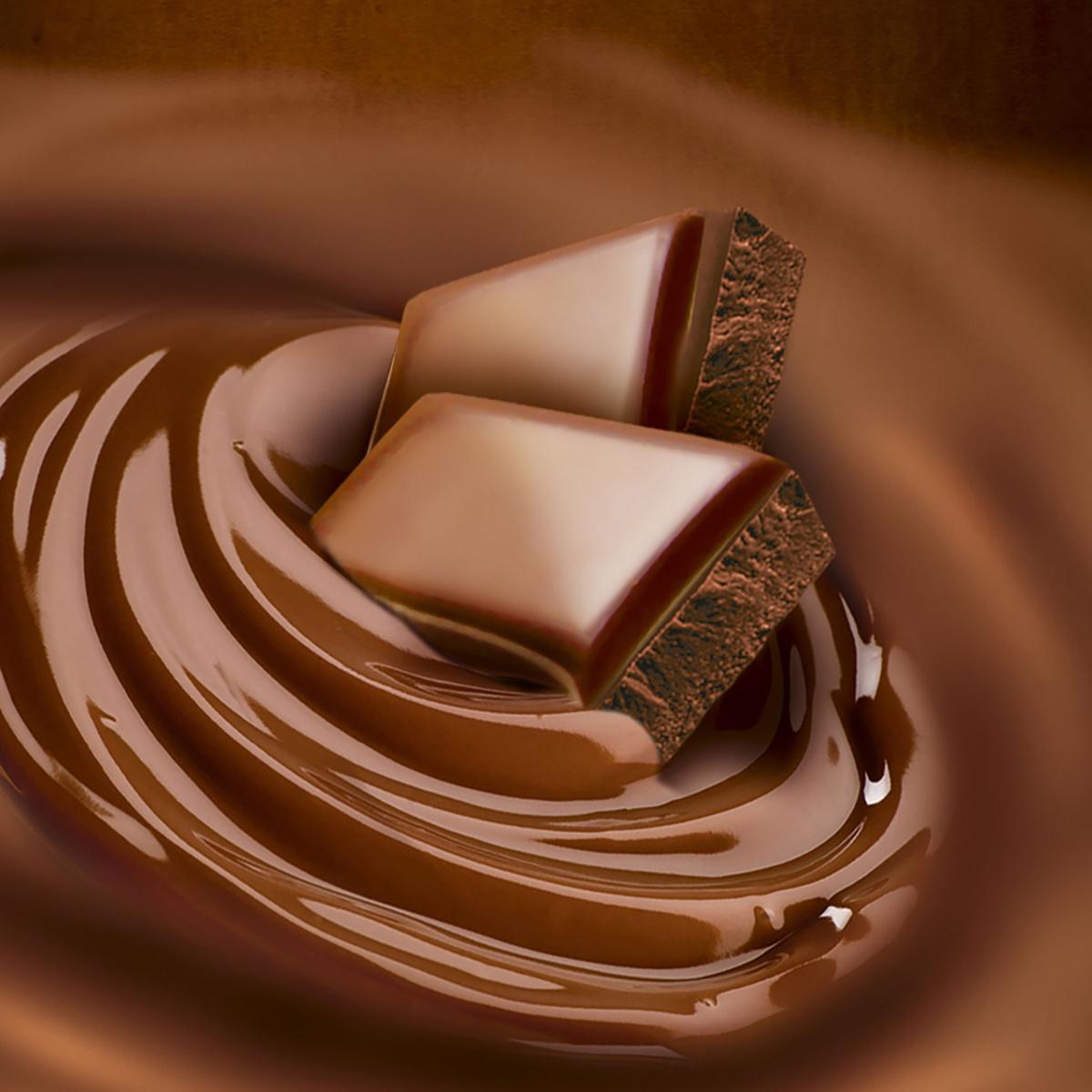 Milk chocolate squares Two squares of milk chocolate floating in a swirl of melted milk chocolate.