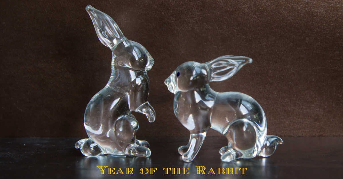 It's the Year of the Rabbit. Two glass rabbits and words Year of the Rabbit.