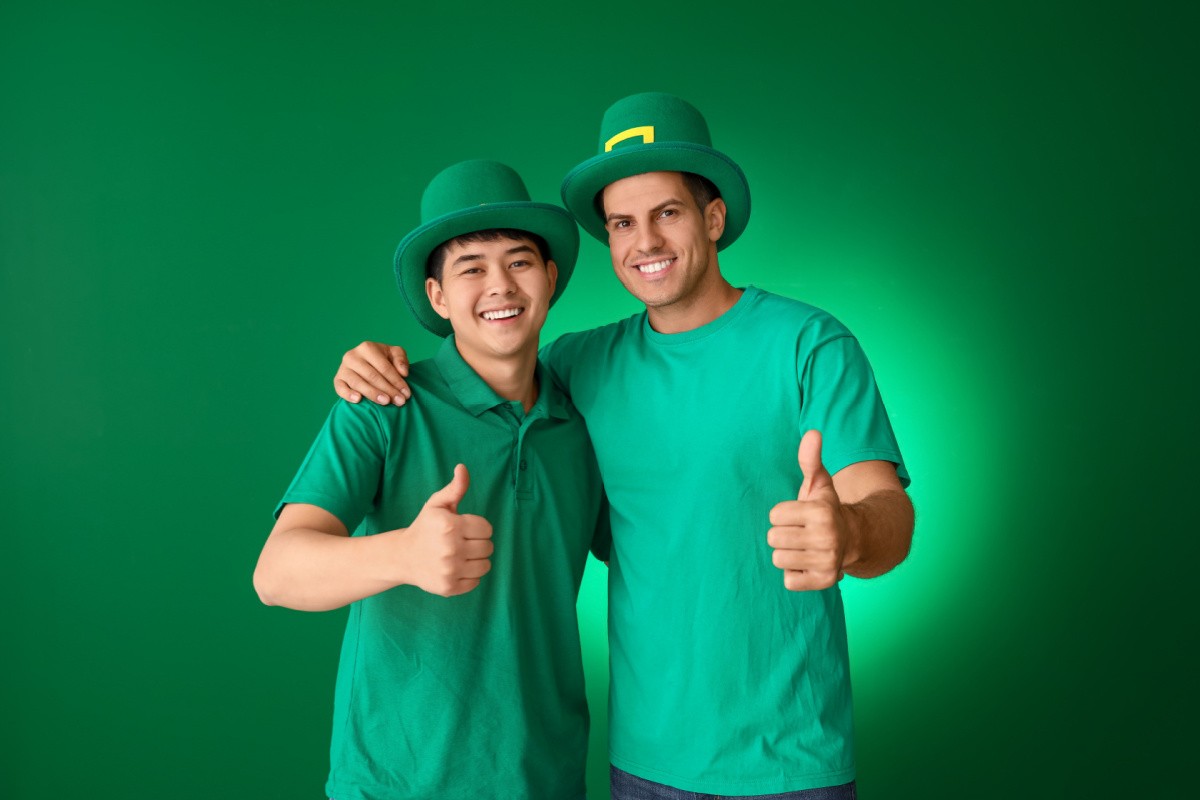 Men wearing green Two men wearing green on St. Patrick's Day giving thumbs up with green top hats inspired by leprechauns on their heads.