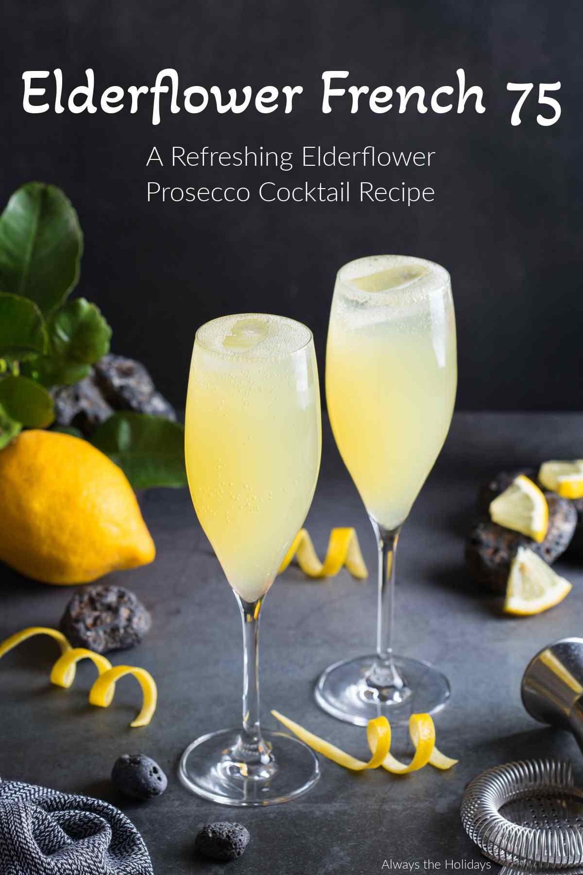 Head to Always the Holidays to get an elderflower Prosecco cocktail recipe to celebrate National Prosecco Day! #ProseccoCocktail #NationalProseccoDay Text that reads "Elderflower French 75 - a refreshing elderflower Prosecco cocktail recipe" above two Prosecco cocktails in flutes for National Prosecco Day with lemon zest and slices around the base, with a jigger and a whole lemon beside them.