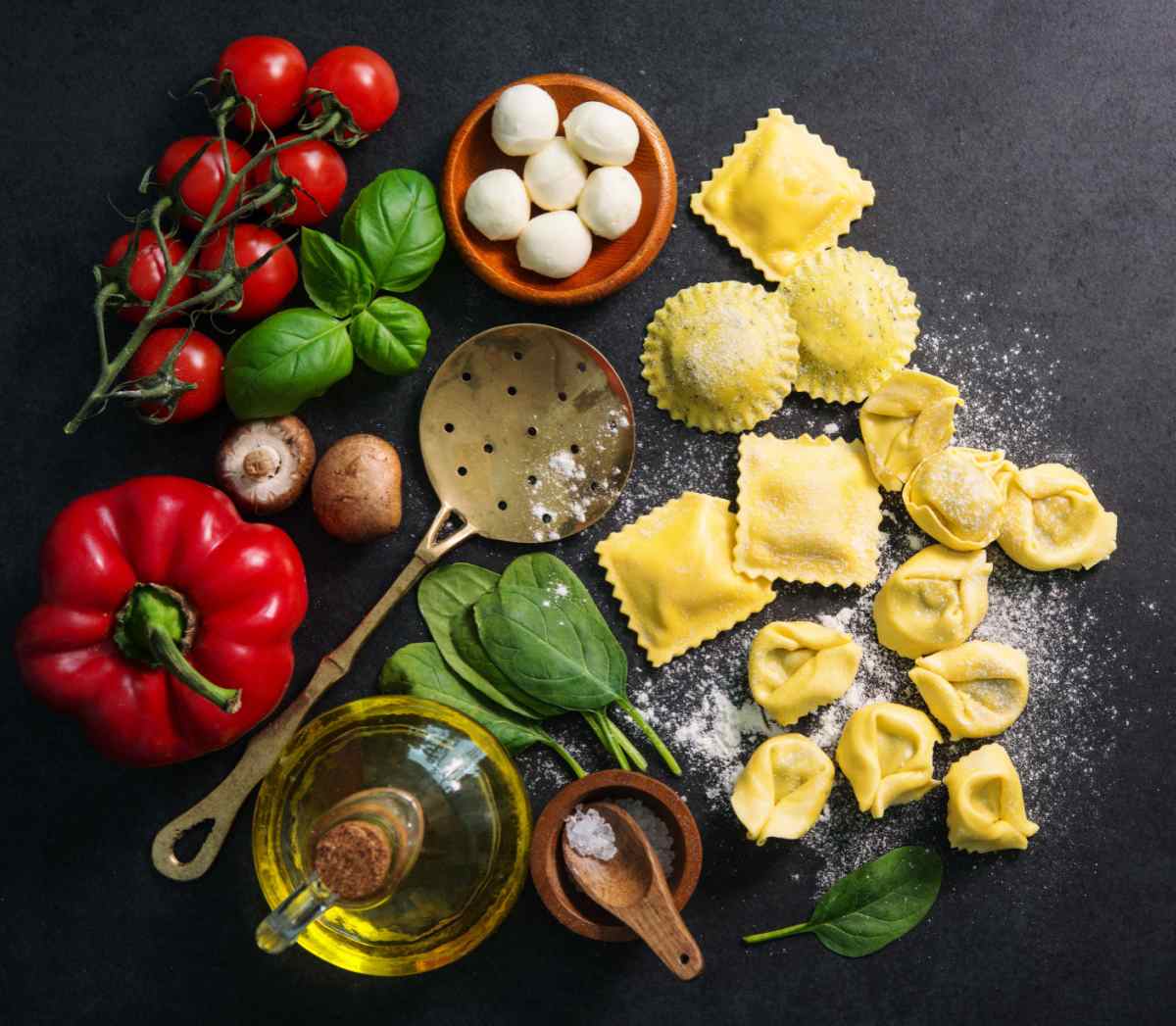 Stuffed types of pasta Various stuffed pasta types including ravioli and tortellini surrounded by typical pasta ingredients like mozzarella, olive oil, salt, tomatoes, basil and a red pepper.