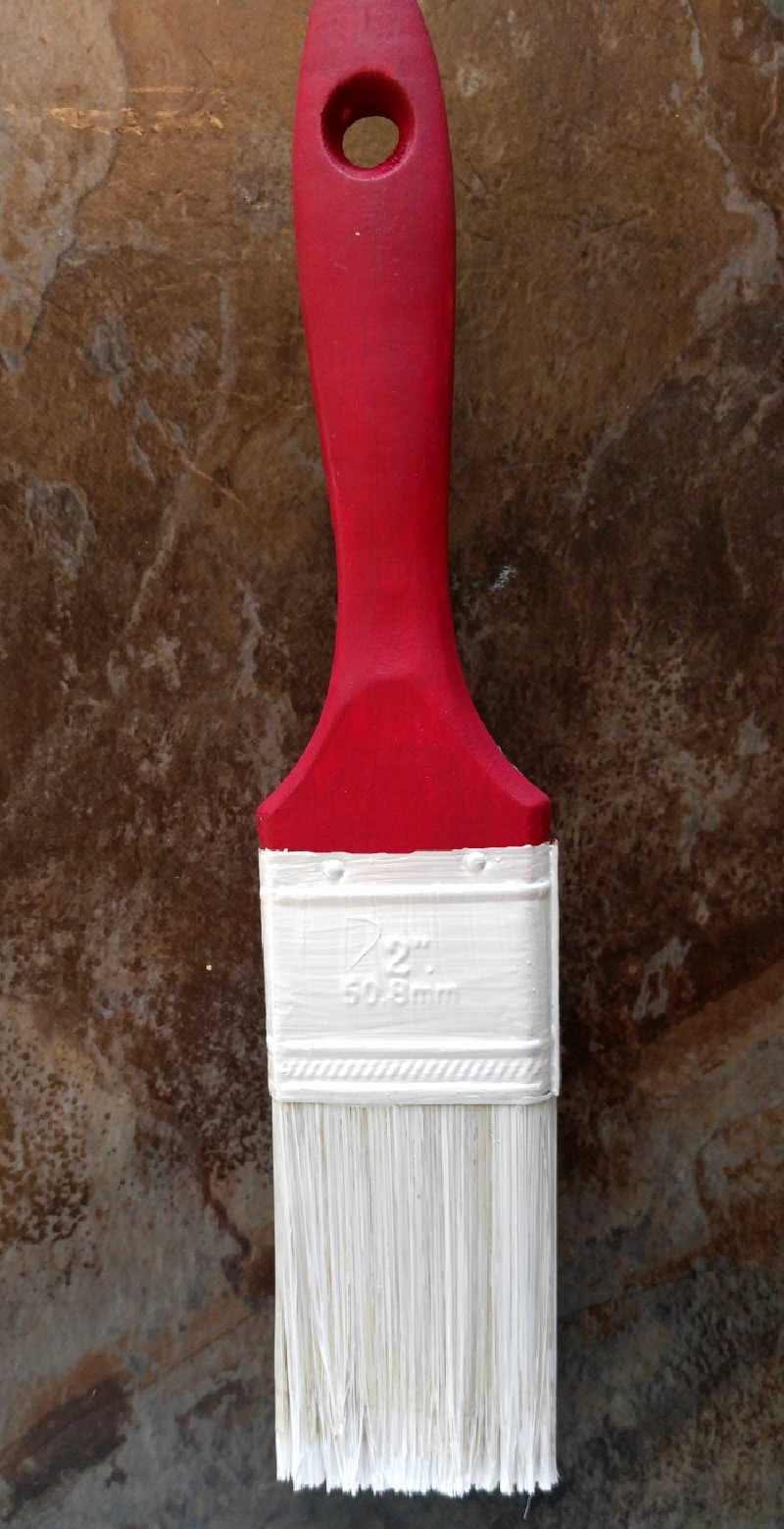 Paint the paintbrush with acrylic paints. Paintbrush painted with wooden part red, and metal part and bristles white.