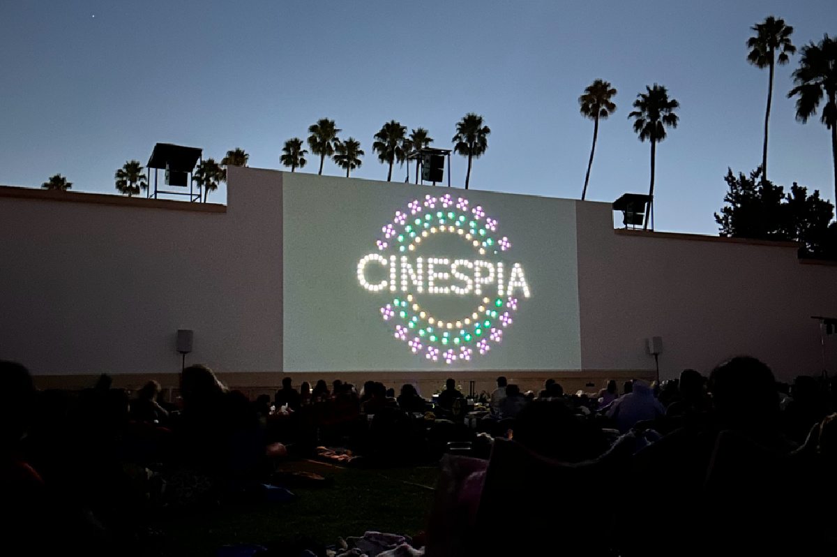 Cinespia movie screening An outdoor summer movie screening in the Hollywood Forever Cemetery in Los Angeles, California, with the name Cinespia projected on the wall.